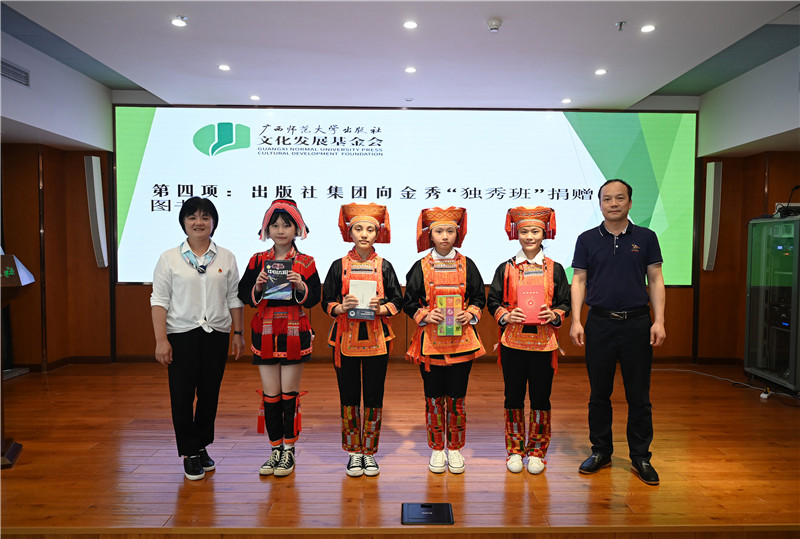 廣西師范大學(xué)出版社集團副總裁、工會(huì )主席莫曲波（右一）代表出版社向金秀“獨秀班”同學(xué)贈送圖書(shū)（李顯楊攝）.jpg