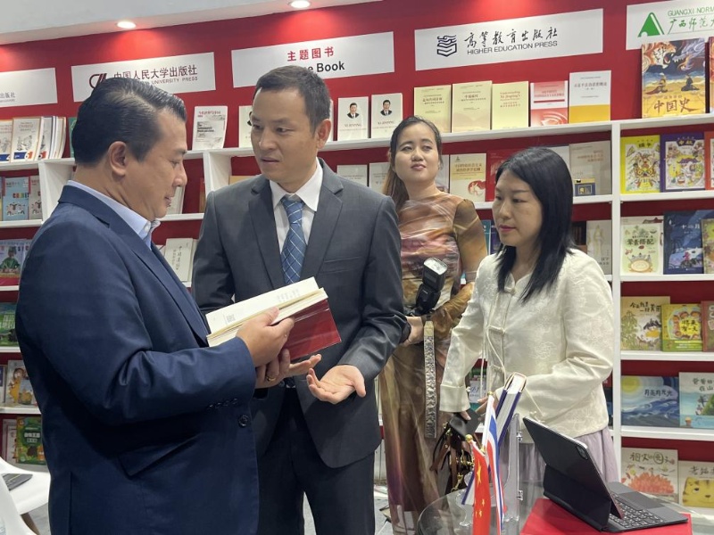 泰國書(shū)商和出版商協(xié)會(huì )主席蘇維奇（左一）在翻閱《近鏡頭：溫暖的瞬間》。（盧雯 攝）jpg_副本.jpg