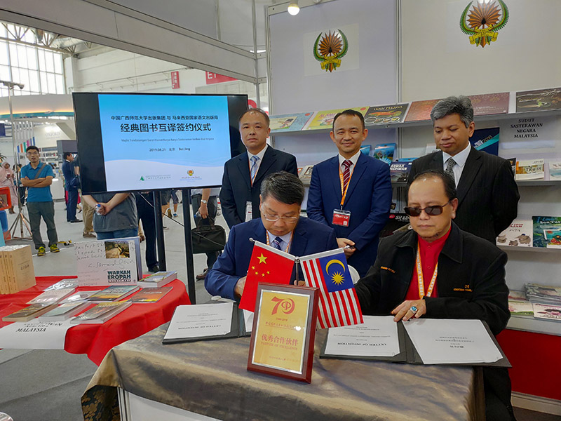 廣西師范大學(xué)出版社集團黨委書(shū)記、董事長(cháng)張藝兵（左前一）與馬來(lái)西亞國家語(yǔ)文出版局理事長(cháng)Datuk Abang Sallehuddin Abang Shokeran簽訂合約（陳子鋒攝）.jpg