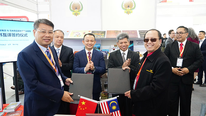 廣西師范大學(xué)出版社集團黨委書(shū)記、董事長(cháng)張藝兵（左前一）與馬來(lái)西亞國家語(yǔ)文出版局理事長(cháng)Datuk Abang Sallehuddin Abang Shokeran交換簽約文件（陳子鋒攝）.jpg