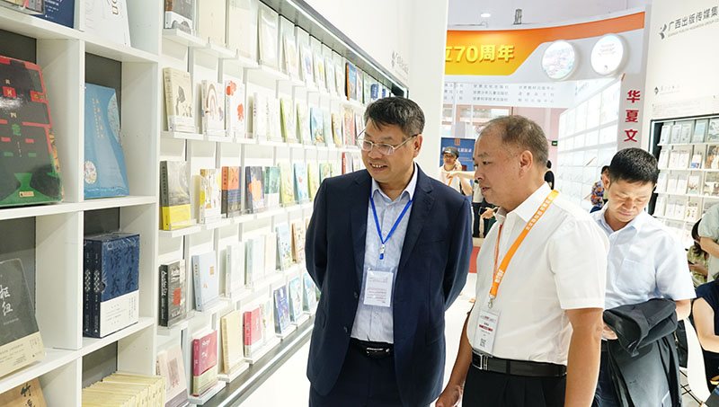 集團公司黨委書(shū)記、董事長(cháng)張藝兵向校黨委副書(shū)記趙鐵詳細介紹出版社圖書(shū)（陳子鋒攝）.JPG